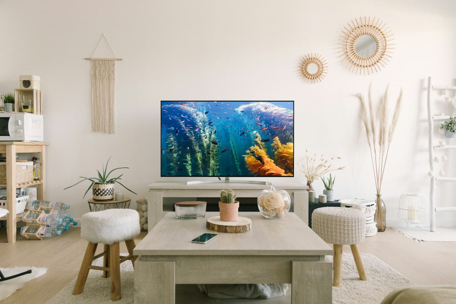 A flat-screen TV on a media console in a bright living room