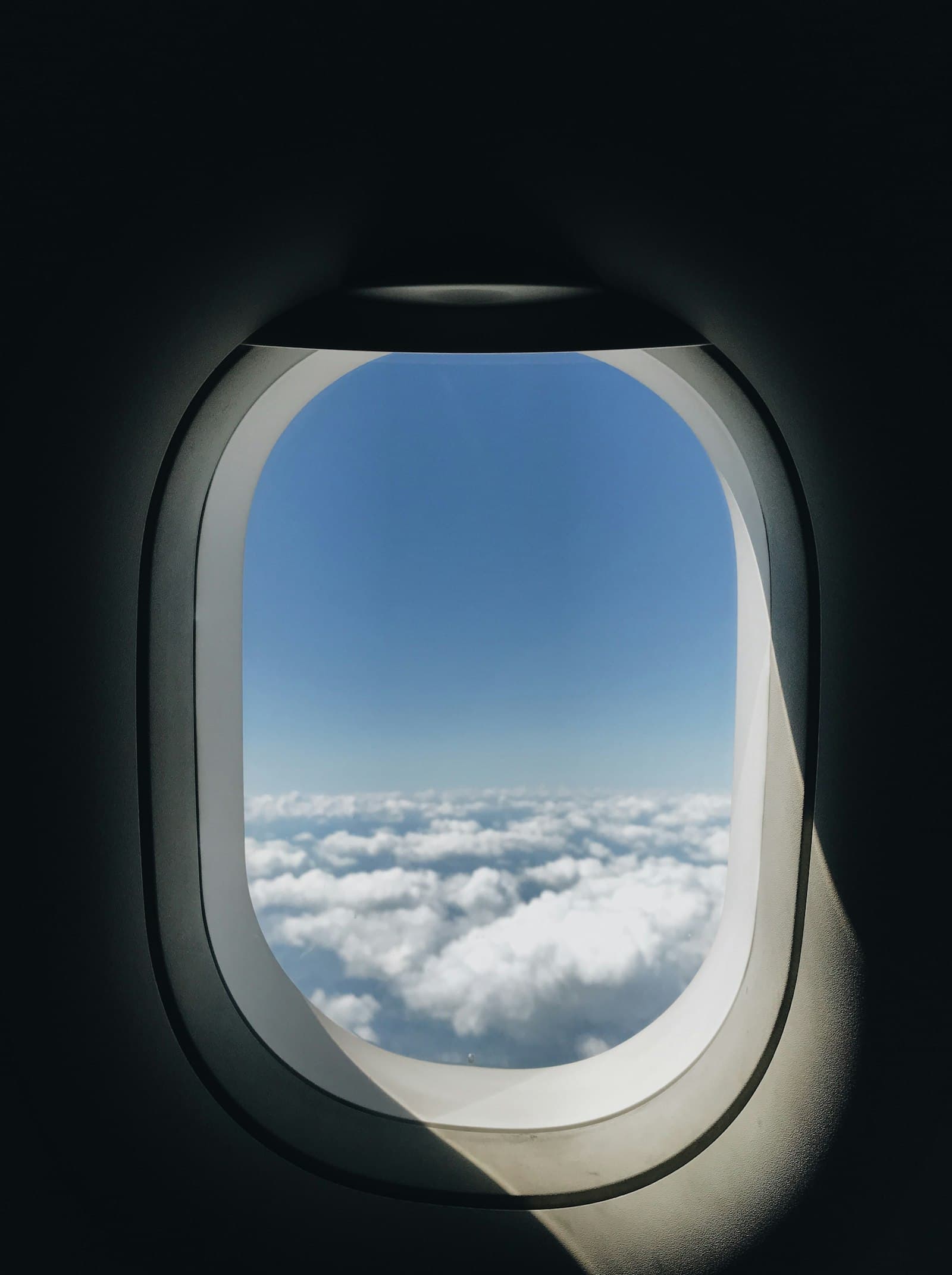 View from an airplane window over clouds and mountains