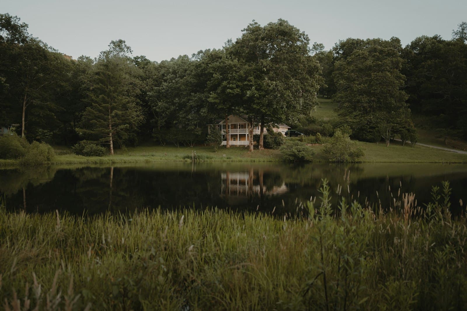 A vacation rental house among trees on the shore of a calm lake