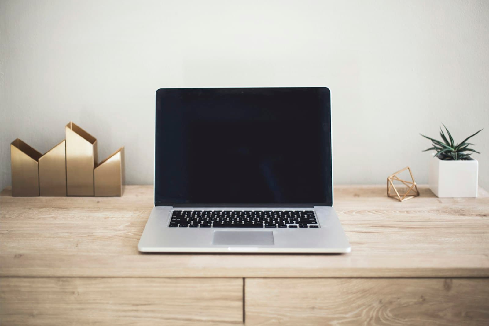 A laptop on a wooden desk in a home office