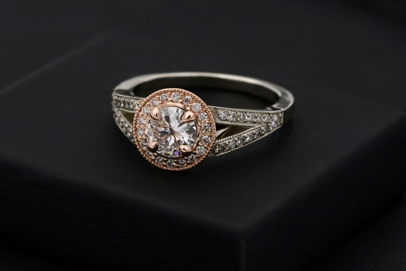 A diamond engagement ring displayed on a black box