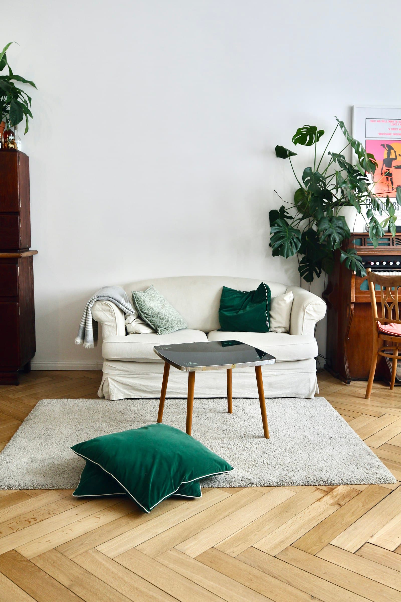 A white sofa with a green throw pillow in a cozy living room