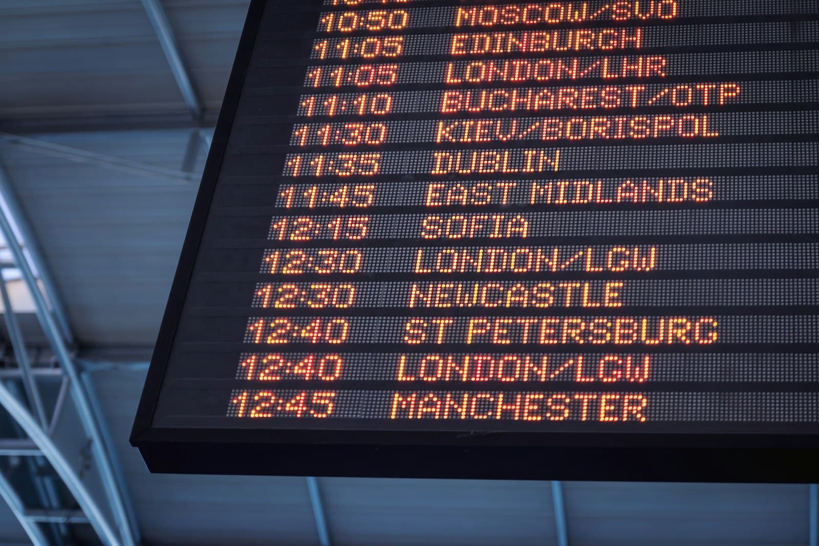 An airport departures board listing international flights