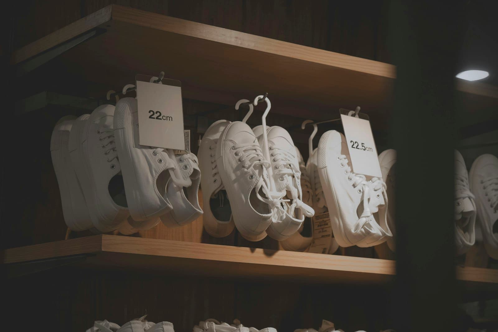 White sneakers with price tags on a shoe store shelf